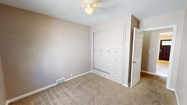 unfurnished bedroom with light carpet, a closet, and ceiling fan