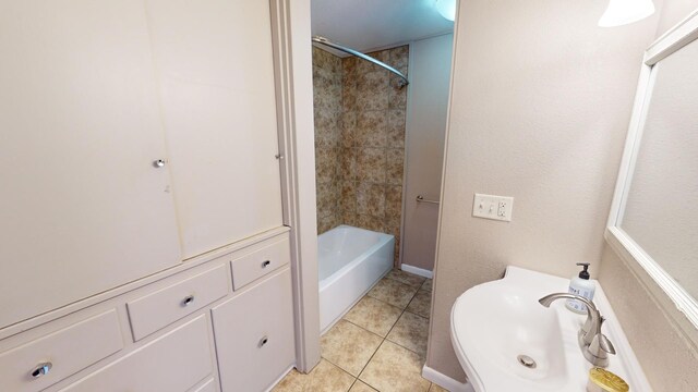 bathroom featuring tile patterned floors, tiled shower / bath combo, and sink