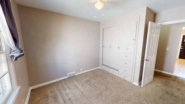 unfurnished bedroom with a closet, carpet floors, and ceiling fan