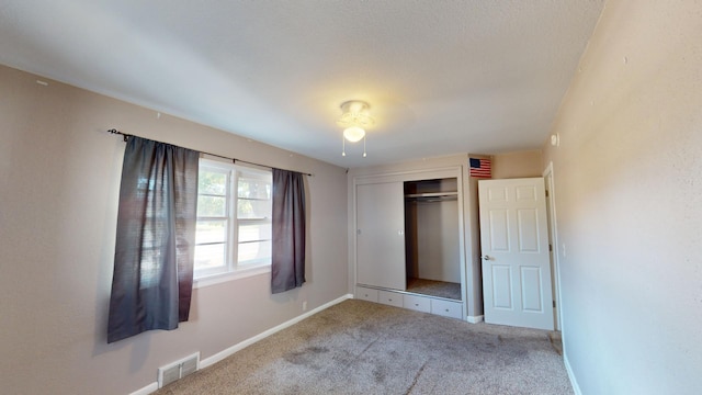 unfurnished bedroom with carpet and a closet