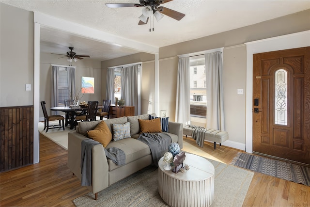 living room with ceiling fan, dark hardwood / wood-style flooring, and a textured ceiling