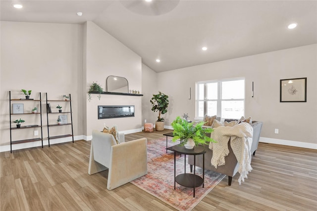 living room featuring light hardwood / wood-style floors and high vaulted ceiling