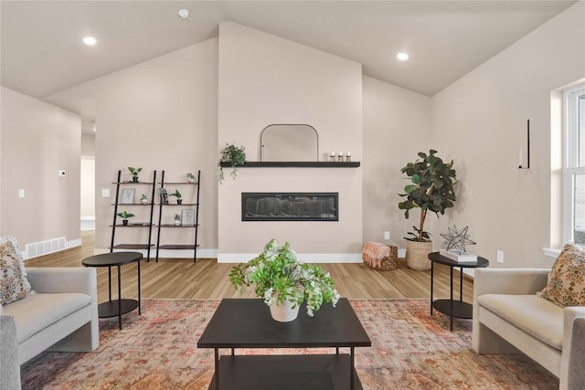 living room with vaulted ceiling and hardwood / wood-style flooring