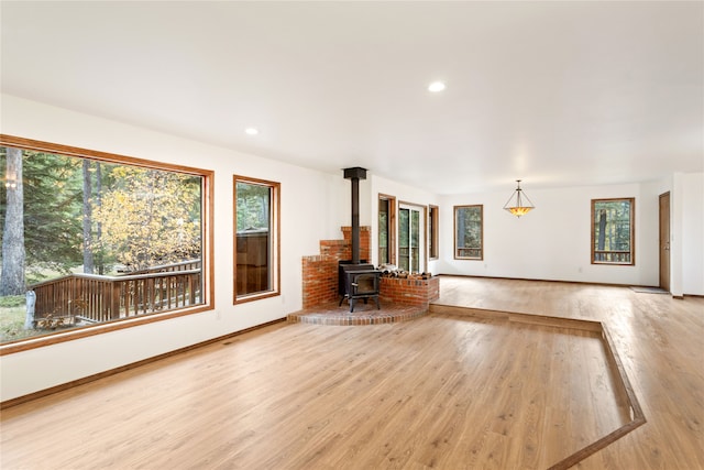 unfurnished living room featuring light wood-type flooring and a wood stove