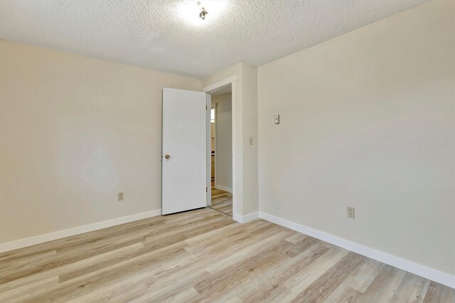 20622 US Highway 10 E, Clinton, MT 59825 - unfurnished room featuring light wood-type flooring and a textured ceiling