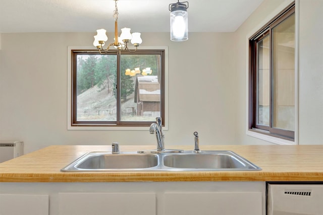 20622 US Highway 10 E, Clinton, MT 59825 - kitchen with light countertops, dishwashing machine, a chandelier, white cabinetry, and hanging light fixtures