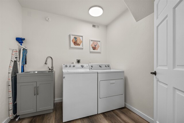 washroom with sink, cabinets, separate washer and dryer, and dark hardwood / wood-style flooring