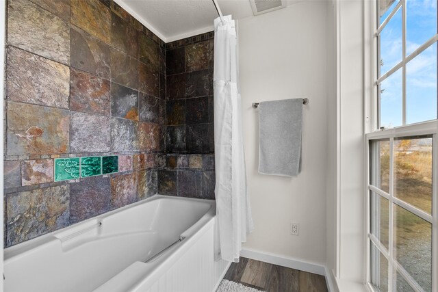 bathroom with shower / bath combo and wood-type flooring