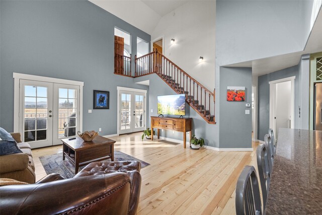 living room featuring hardwood / wood-style floors, french doors, and high vaulted ceiling