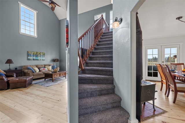 stairway featuring french doors, wood-type flooring, and ceiling fan