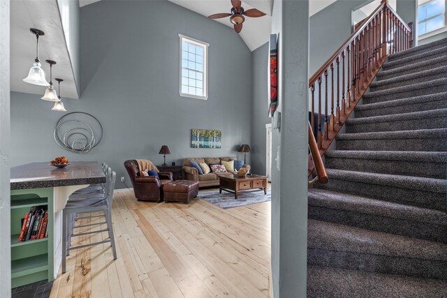 living room with lofted ceiling, wood-type flooring, and ceiling fan