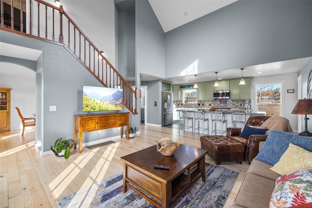 living room featuring light hardwood / wood-style flooring and high vaulted ceiling