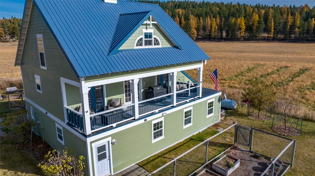 rear view of property with a lawn and a balcony