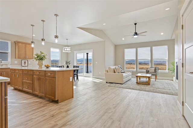 kitchen featuring lofted ceiling, a healthy amount of sunlight, a center island, and light wood-type flooring