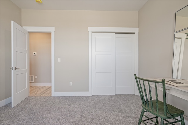 unfurnished bedroom featuring light carpet and a closet