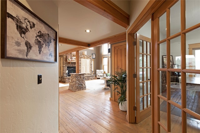 hall featuring french doors, beam ceiling, and light wood-type flooring