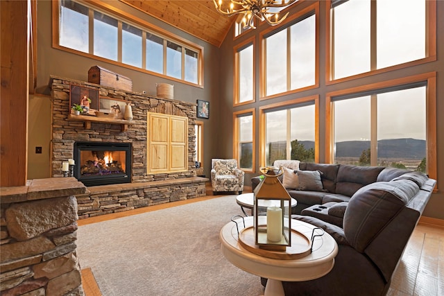 living room featuring a mountain view, high vaulted ceiling, an inviting chandelier, and a fireplace