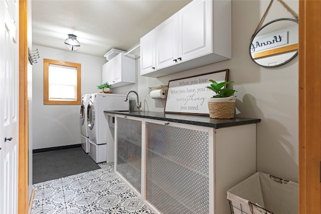 laundry area featuring a textured ceiling, washing machine and dryer, and cabinets