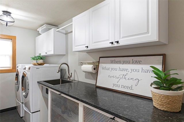 washroom with cabinets, washer and dryer, sink, and a textured ceiling