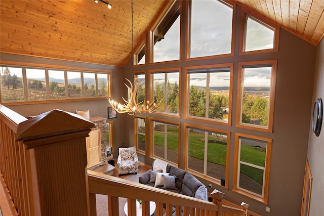 sunroom / solarium featuring wooden ceiling, vaulted ceiling, and a wealth of natural light