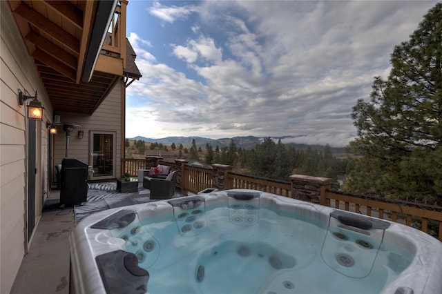 wooden terrace featuring area for grilling, a mountain view, and a hot tub