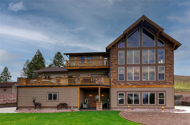 rear view of property with a yard, a patio area, and a balcony