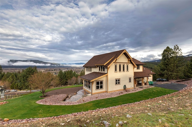 back of property with a yard and a mountain view