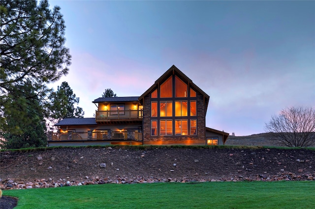 back house at dusk with a lawn