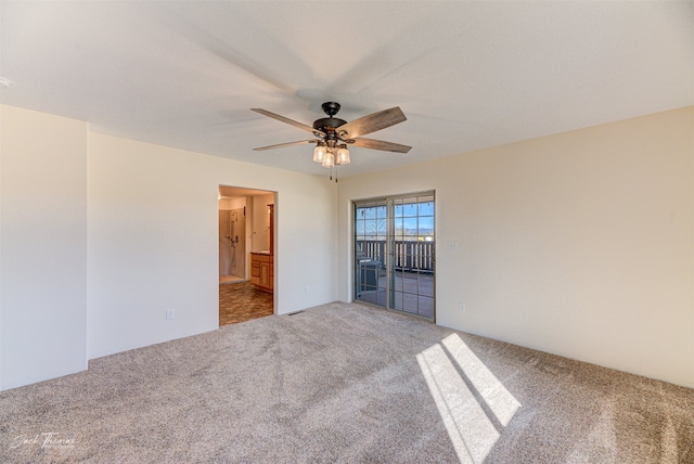 carpeted spare room featuring ceiling fan