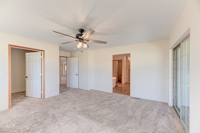 unfurnished bedroom featuring ceiling fan, light carpet, and ensuite bathroom