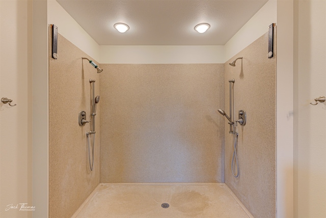 bathroom featuring tiled shower and a textured ceiling