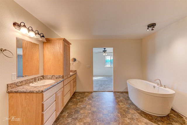 bathroom with vanity, ceiling fan, and a washtub