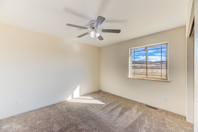 empty room featuring carpet flooring and ceiling fan