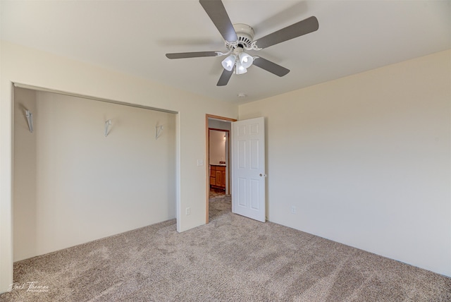 unfurnished bedroom with a closet, light colored carpet, and ceiling fan