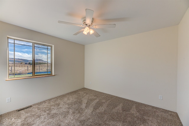 spare room featuring carpet floors and ceiling fan