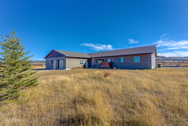 rear view of house featuring an outdoor structure and a deck with mountain view