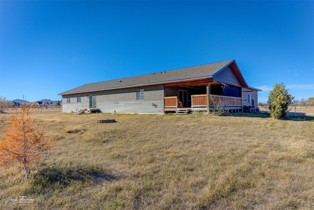 back of house featuring a deck and a yard