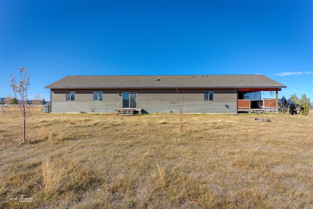 rear view of property featuring a lawn