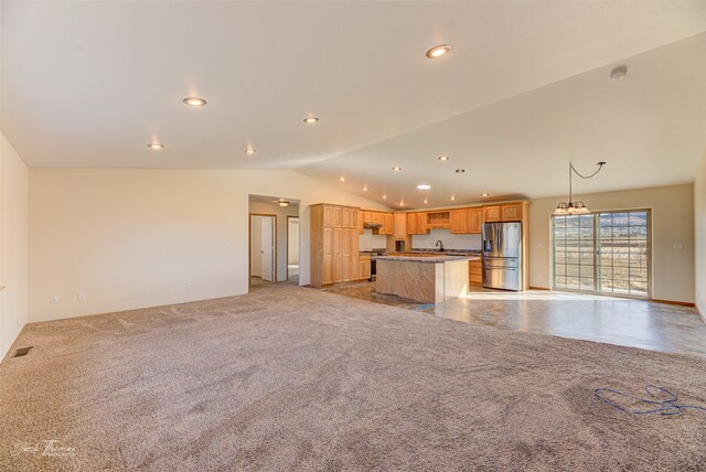 kitchen featuring lofted ceiling, a kitchen island, hanging light fixtures, stainless steel fridge with ice dispenser, and light colored carpet