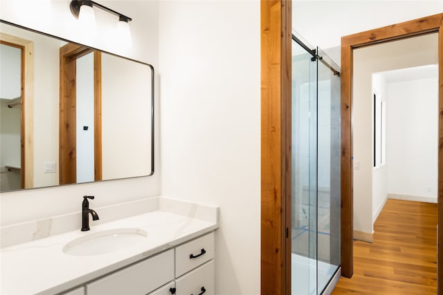 bathroom with vanity, hardwood / wood-style flooring, and walk in shower