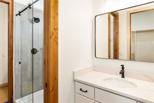 bathroom with a shower with door and vanity