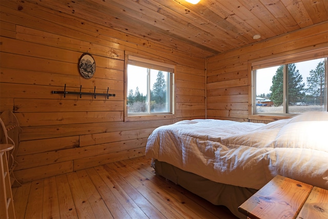 bedroom with wood-type flooring, wooden ceiling, and wood walls