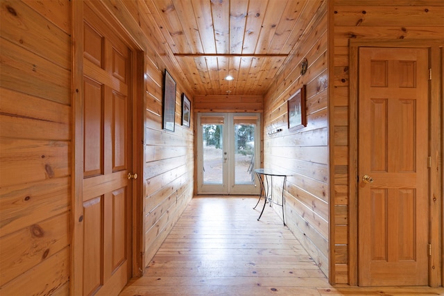 doorway featuring light hardwood / wood-style floors, french doors, wooden walls, and wooden ceiling