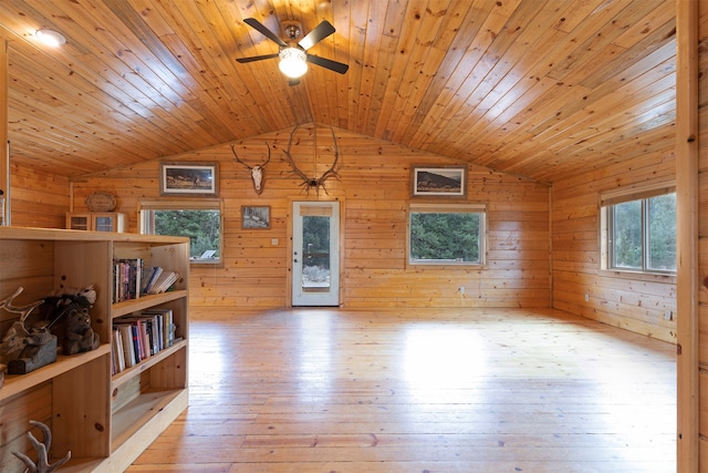 empty room with lofted ceiling, wooden walls, light hardwood / wood-style floors, and wooden ceiling