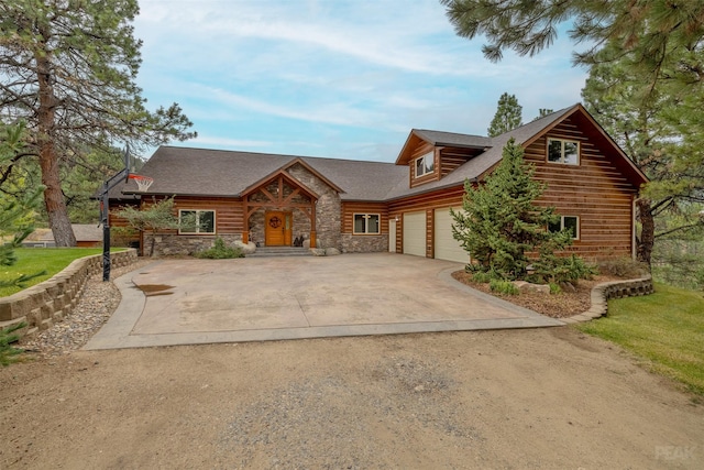 214 Solomon Mountain Rd, Clancy, MT 59634 - log home with concrete driveway, a garage, and stone siding