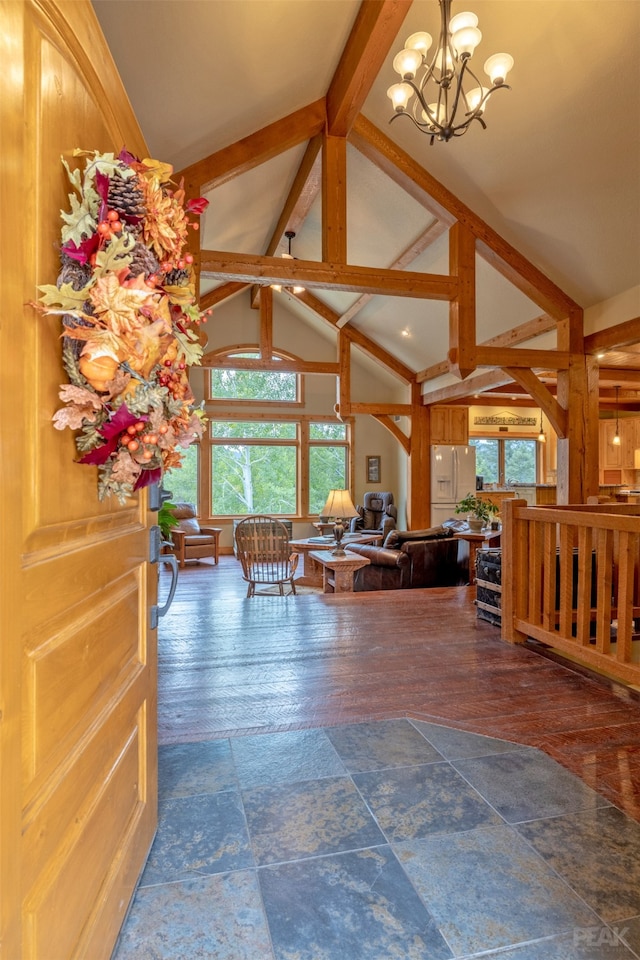 living room with lofted ceiling with beams, a chandelier, plenty of natural light, and dark hardwood / wood-style floors