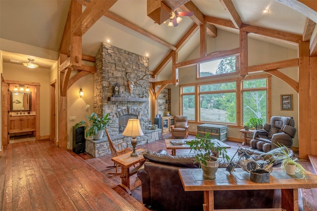 214 Solomon Mountain Rd, Clancy, MT 59634 - living room featuring wood-type flooring, beamed ceiling, high vaulted ceiling, a stone fireplace, and a ceiling fan