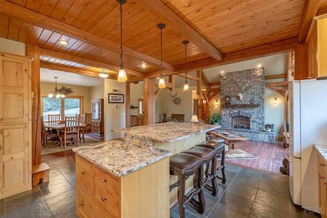 214 Solomon Mountain Rd, Clancy, MT 59634 - kitchen featuring freestanding refrigerator, open floor plan, a wood ceiling with exposed beams, a center island, and light stone counters