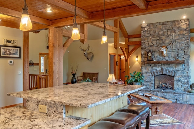 214 Solomon Mountain Rd, Clancy, MT 59634 - kitchen with a wooden ceiling with exposed beams, wood finished floors, light stone counters, a center island, and pendant lighting