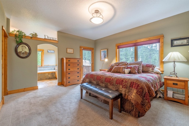 214 Solomon Mountain Rd, Clancy, MT 59634 - bedroom featuring arched walkways, carpet flooring, connected bathroom, and access to outside